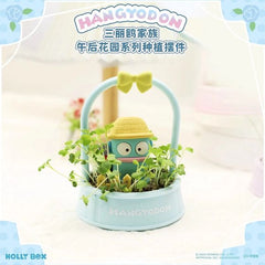 Bring a splash of fun to your indoor garden with the Hangyodon Afternoon Garden Planter Figure from Holly Box! Part of the delightful Sanrio Characters Afternoon Garden Series, this whimsical display features Hangyodon peeking out from a bed of fresh greenery while wearing an adorable straw gardening hat.
Set inside a pastel blue basket-style planter accented with a cheerful yellow bow, this charming scene combines Sanrio cuteness with botanical inspiration. Tiny fence details and surrounding sprouts creat
