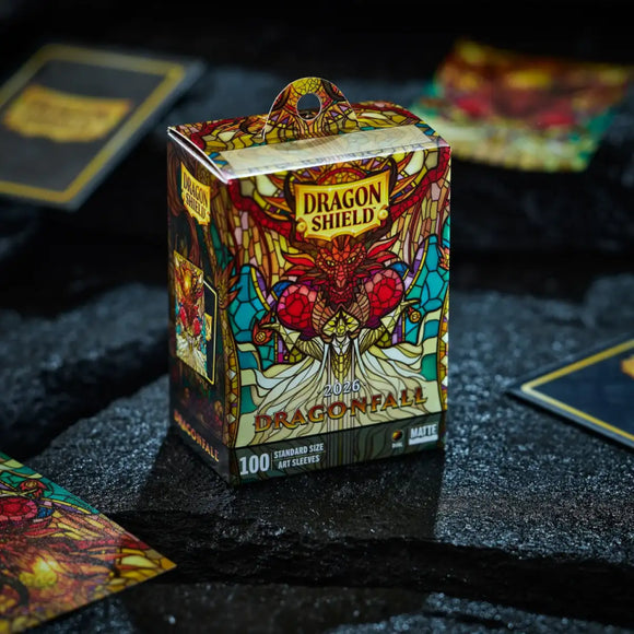 The Dragonfall sleeves from Dragon Shield commemorate the brand's first annual event dedicated to dragons, fantasy, and community. Inspired by the Draconid meteor shower, their artwork depicts a dragon's arrival from the world of Arcania into the mortal realm. The design is rendered in a stained-glass style, showing dragons and the Herald announcing the arrival of this year's dragon.

These sleeves are the brand's first with borderless artwork, meaning the illustration extends right to the edge of the sleev