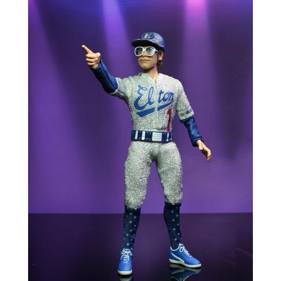 In partnership with Elton John, NECA introduces a deluxe tribute to the legend and his profound influence on both music and fashion. The Elton John Live in '75 action figure stands 8 inches (20.3 cm) tall and sports one of his most famous stage costumes: the glammed-up baseball uniform from his October 1975 concerts at Dodger Stadium, Los Angeles. These were the largest concerts ever by a solo artist at the time, and we've gone all out to commemorate that landmark occasion with a scaled piano as it appeared