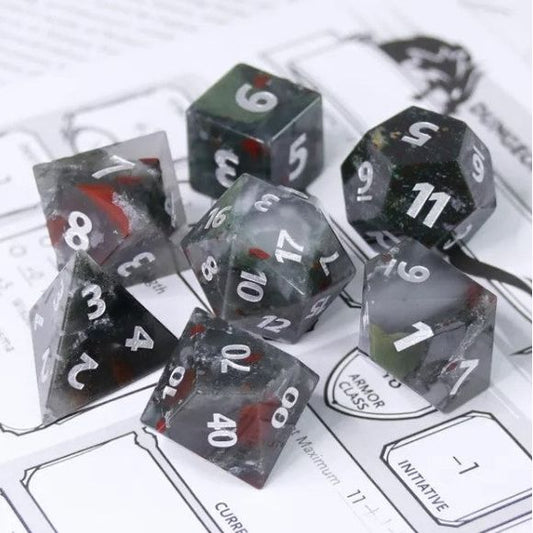 The perfect companion for your gaming needs! These premium, high-end cut stone polyhedral dice are exactly what you've been searching for that upcoming game night with the group. Each set weighs roughly 2.5 ounces and are stored in a quality, brushed metal tin with foam insert. These dice are a rich natural stone with nice weight to them and engraved each with crisp, easy-to-read numerals. Many styles and colors are available.

This set includes on of each: d20, d12, d10, d10 (percentile), d8, d6, and a d4