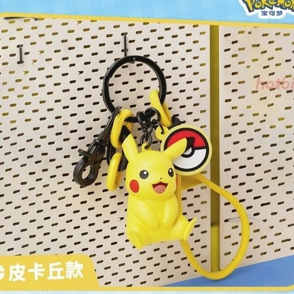 Take Pikachu along on every adventure with this adorable Pikachu Charm Keychain by Langbowang! Featuring Pikachu in a cheerful seated pose with its signature bright smile and rosy cheeks, this collectible accessory is perfect for Pokémon fans looking to add a touch of fun to their everyday carry.

The keychain includes a detailed Pikachu figure, a classic Poké Ball charm, colorful accent links, a durable metal clasp, and a convenient wrist strap for easy attachment to keys, backpacks, purses, and more. Its