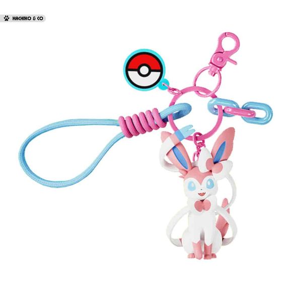 Add a touch of Fairy-type elegance to your everyday accessories with this adorable Sylveon Charm Keychain by Langbowang! Featuring Sylveon in a cute chibi-style design, complete with its signature ribbon-like feelers and pastel pink-and-blue color palette, this charming accessory is perfect for Pokémon fans who love one of the most beloved Eeveelutions.

The keychain includes a detailed Sylveon figure, a Poké Ball charm, colorful decorative links, and a convenient wrist loop attachment for easy carrying. Wh