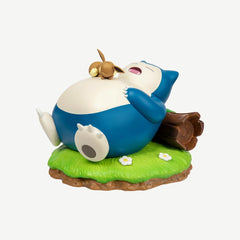 Take a peaceful break with Snorlax and Eevee in the Funism Pokémon Partner Series Prime Figure! This beautifully sculpted PVC statue captures an adorable moment as Eevee naps peacefully atop a sleeping Snorlax while the pair relax beside a fallen log in a lush grassy setting. Every detail—from the textured grass and flowers to the realistic wood log and expressive Pokémon sculpting—brings this tranquil scene to life. Standing approximately 5 inches tall, this premium display is also impressively wide and de